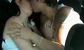 inked guy making out with cute girl during car ride