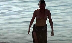 Small-breasted blonde poses on nudist beach.