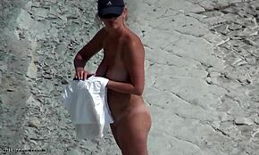 blonde with natural breasts showing off her body on a beach!