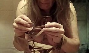 Female slave endures self-bondage with clothespins and belt whipping