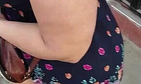 Following a mature woman on the street with skirt and thong